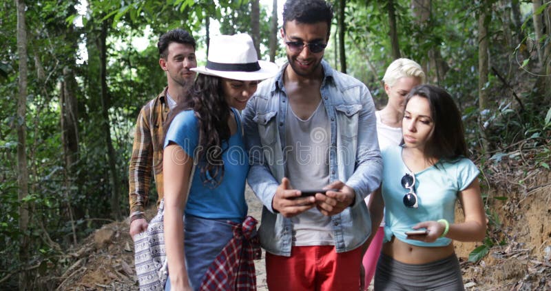 Groupe de carte de touristes de contrôle utilisant le téléphone intelligent de cellules augmentant dans l'itinéraire de trekking banque de vidéos