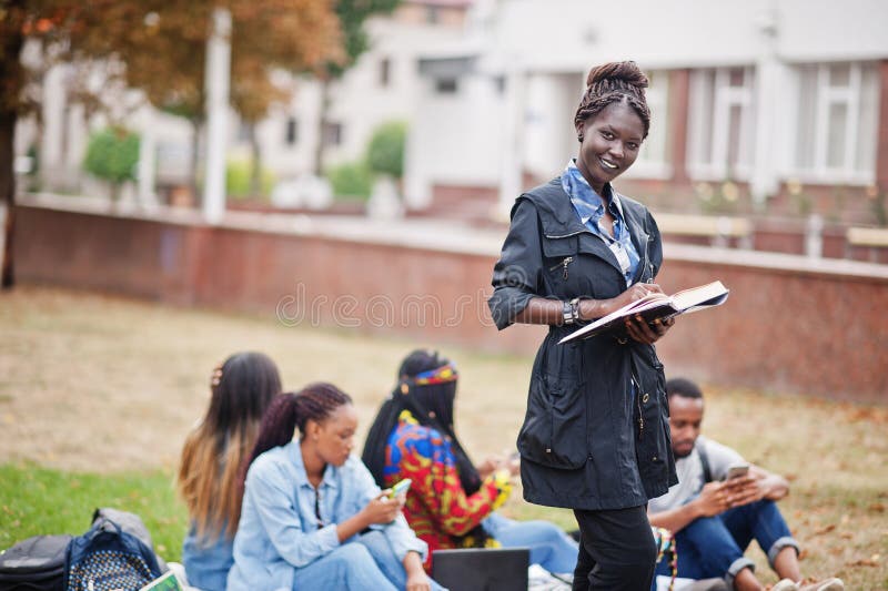 Group of five african college students spending time together on campus at university yard. Black afro friends studying. Education theme. Group of five african college students spending time together on campus at university yard. Black afro friends studying. Education theme