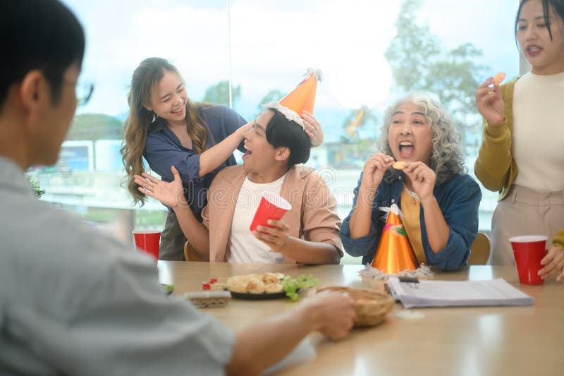Groupe de collègues joyeux profitant à la fête d'anniversaire de bureau photos libres de droits