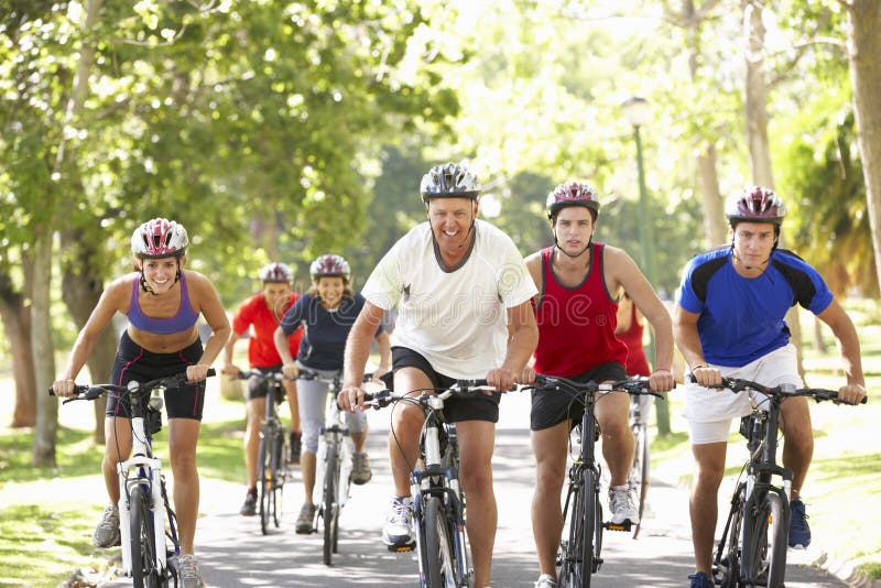 Groupe de cyclistes sur le tour de cycle par le parc photos libres de droits