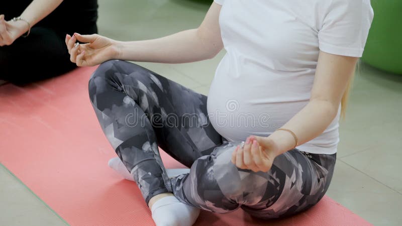 Groupe de femmes enceintes heureuses exerçant le yoga et méditer dans la pose du lotus dans la salle de sport banque de vidéos