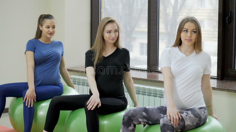 Groupe de femmes enceintes heureuses exerçant le yoga et méditer dans la pose du lotus dans la salle de sport clips vidéos