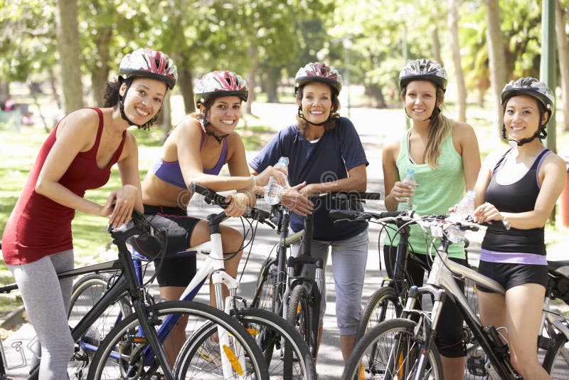 Groupe de femmes se reposant pendant le tour de cycle par le parc photographie stock