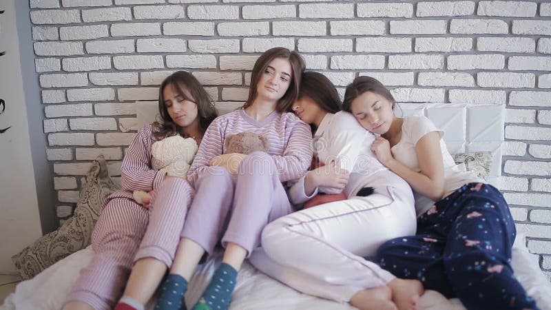 Groupe de filles dans leurs pyjamas dormant dans le lit après partie clips vidéos
