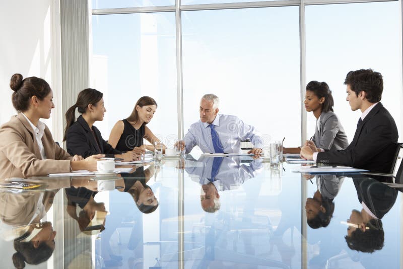 Groupe de gens d'affaires ayant la réunion du conseil d'administration autour du Tableau en verre images libres de droits Groupe de gens d'affaires ayant la réunion du conseil d'administration autour du Tableau en verre images libres de droits