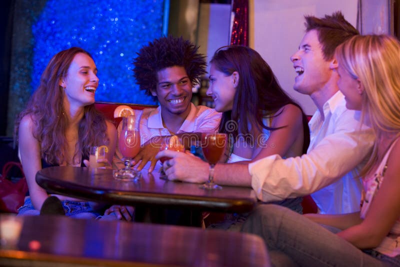 Groupe de jeunes adultes dans parler de boîte de nuit images stock Groupe de jeunes adultes dans parler de boîte de nuit images stock