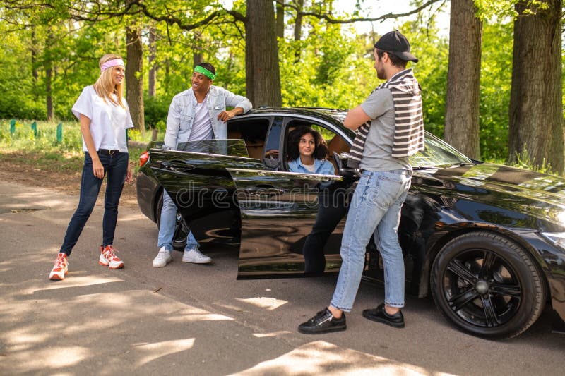 Groupe de jeunes discutant de leur accident de voiture et élaborant un plan ensemble images libres de droits