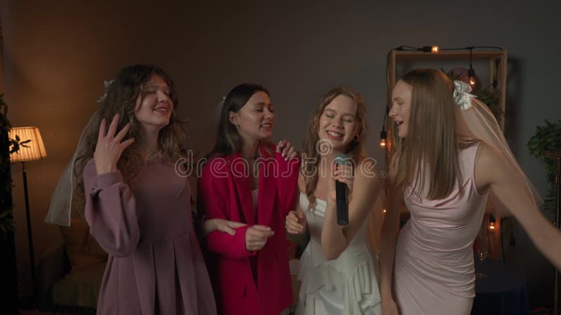 Groupe de jeunes femmes amies et mariées célébrant la fête de bachelorette à la maison mariée et demoiselles d'honneur en s'amusan clips vidéos