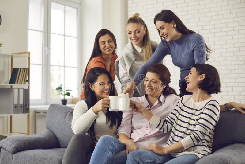 Groupe de jeunes femmes heureuses à boire du café, riant et apprécier le temps de s'amuser images stock