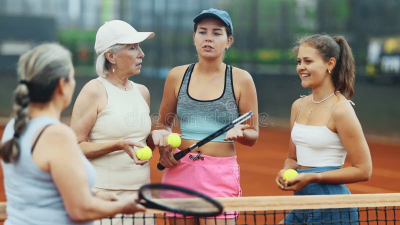 Groupe de joueuses de tennis jeunes filles et femmes âgées debout sur le terrain extérieur après le match le jour d'été et clips vidéos