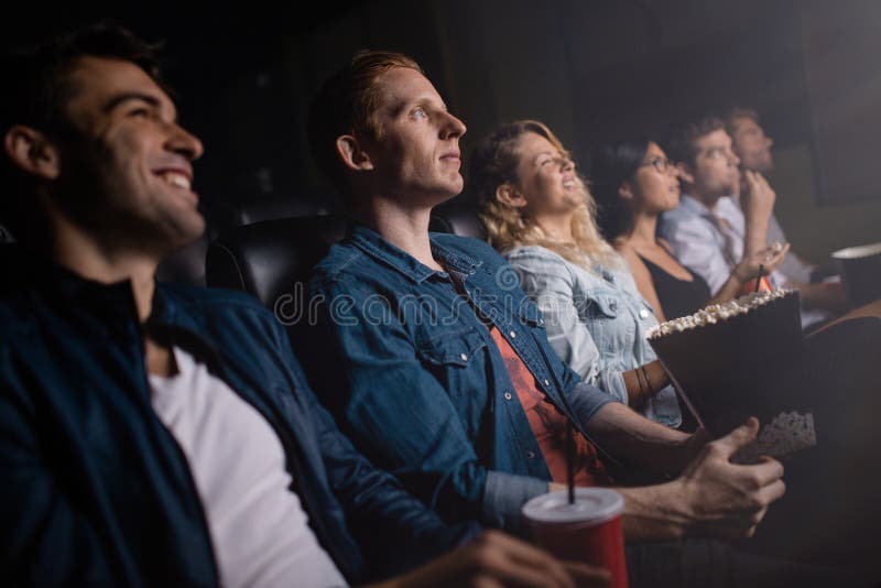 Group of people in theater watching movie. Young men with friends in cinema. Group of people in theater watching movie. Young men with friends in cinema.