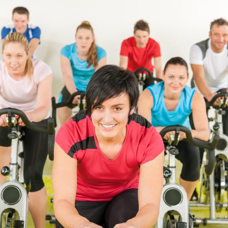 Groupe de personnes de forme physique sur le vélo de gymnastique image stock Groupe de personnes de forme physique sur le vélo de gymnastique image stock