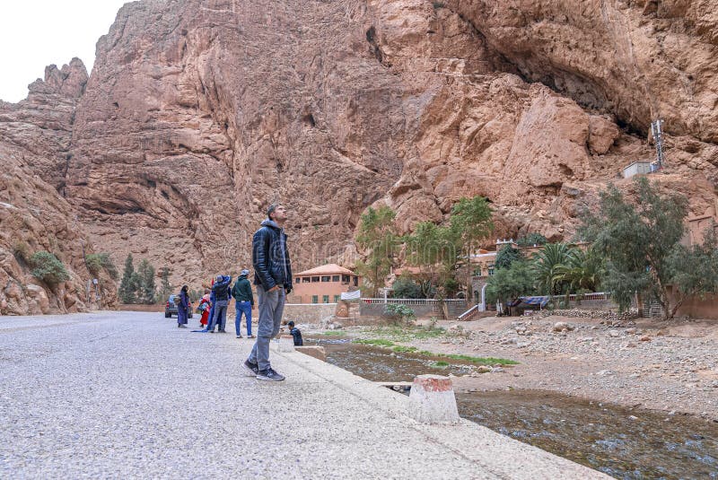 Groupe de personnes debout sur le bord de la route devant la falaise rocheuse. Maroc. 10 octobre 2021. touristes en bord de route admirant la nature pendant les vacances