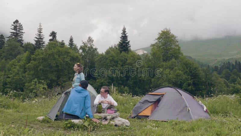 Groupe de personnes de touristes se reposant dans le terrain de camping tandis qu'été augmentant en montagne clips vidéos