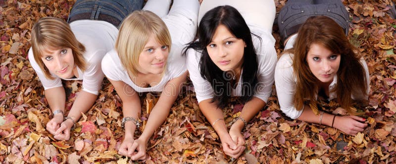 Groupe De Quatre Filles Se Situant Dans Des Lames D Automne Photo Stock