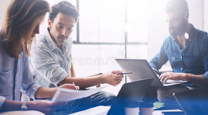 Groupe de trois jeunes collègues travaillant ensemble au studio coworking moderne Femme dirigeant la main sur le document sur pap photo libre de droits Groupe de trois jeunes collègues travaillant ensemble au studio coworking moderne Femme dirigeant la main sur le document sur pap photo libre de droits