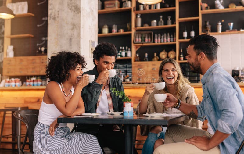 Groupe divers d'amis appréciant le café ensemble images stock
