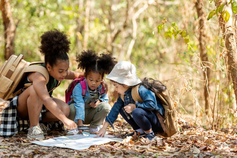 Groupe famille enfants vérifier la carte pour explorer et trouver des directions dans la nature campagnarde et l'aventure