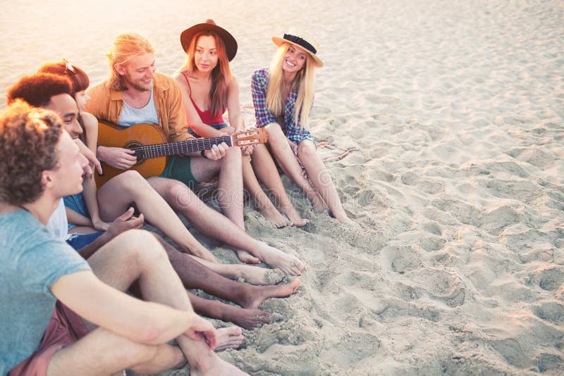 Happy group of friend having party and playing guitar on the beach. Happy group of friend having party and playing guitar on the beach