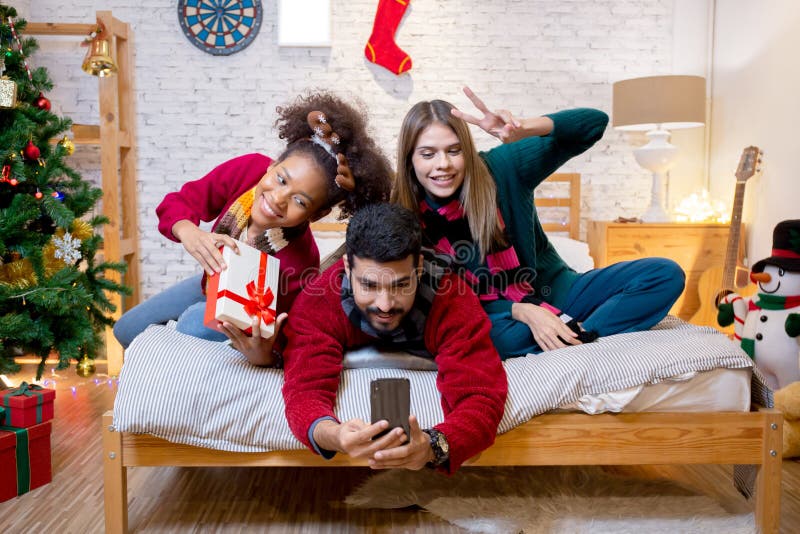 Groupe jeunes amis prendre selfie avec excité et profiter avec smartphone ensemble à la maison. photo stock