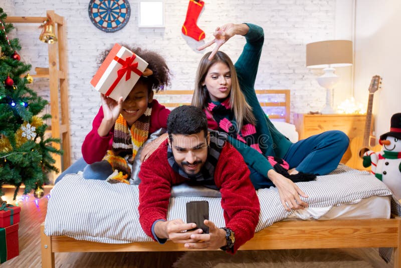 Groupe jeunes amis prendre selfie avec excité et profiter avec smartphone ensemble à la maison. photo libre de droits
