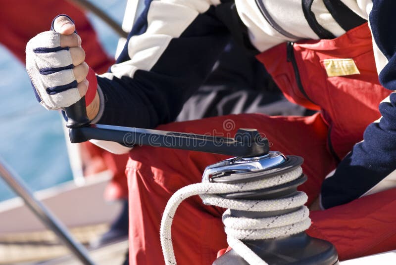 Detail of a man working with hands and gloves on the winch of a sailboat during Regatta Barcolana - (Trieste, Italy 2007). Detail of a man working with hands and gloves on the winch of a sailboat during Regatta Barcolana - (Trieste, Italy 2007)