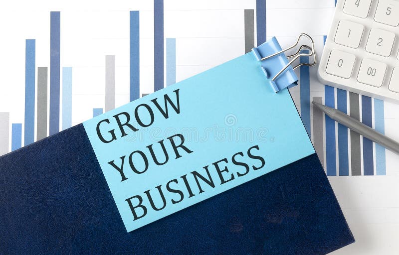 GROW YOUR BUSINESS on sticky note on notebook on the chart background royalty free stock photo