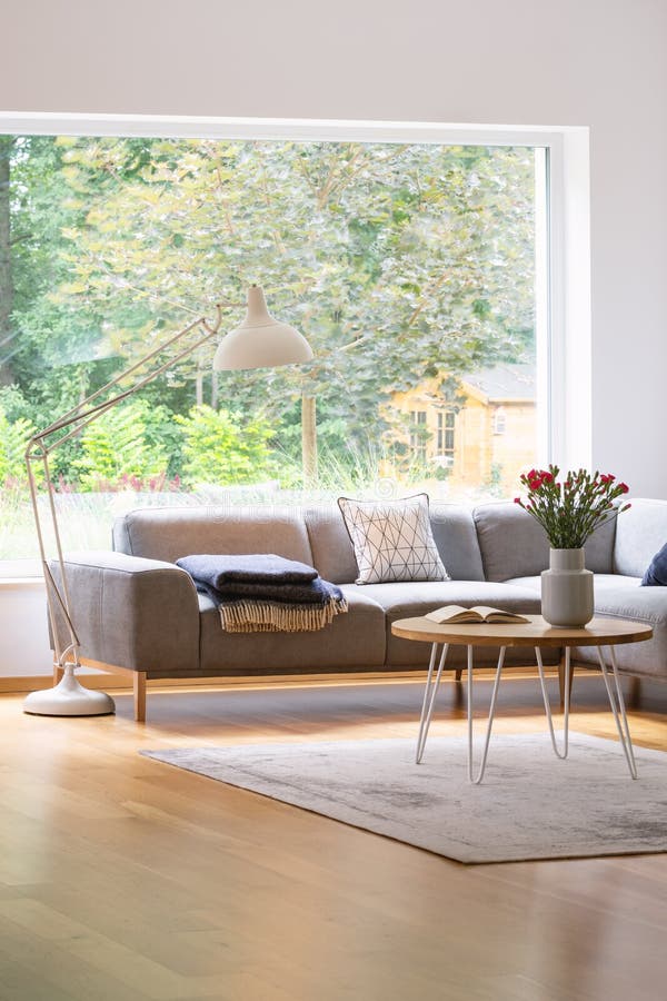 Große, industrielle Artstehlampe über einem eleganten Sofa in einem weißen und natürlichen, skandinavischen Wohnzimmerinnenraum m stockfotos Große, industrielle Artstehlampe über einem eleganten Sofa in einem weißen und natürlichen, skandinavischen Wohnzimmerinnenraum m stockfotos