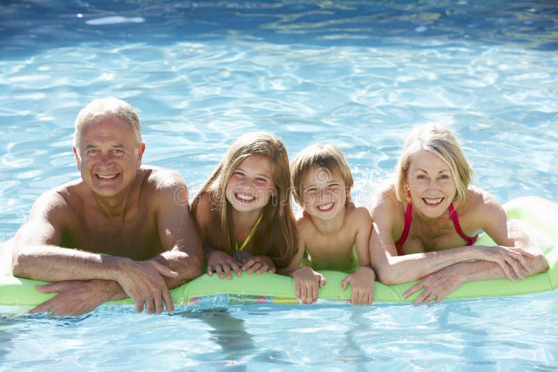 Großeltern und Enkelkinder, die sich zusammen im Swimmingpool entspannen lizenzfreies stockbild Großeltern und Enkelkinder, die sich zusammen im Swimmingpool entspannen lizenzfreies stockbild