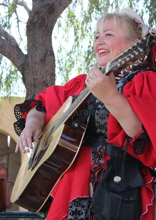 Großer Frauenmusiker, der Gitarre spielt lizenzfreie stockbilder Großer Frauenmusiker, der Gitarre spielt lizenzfreie stockbilder