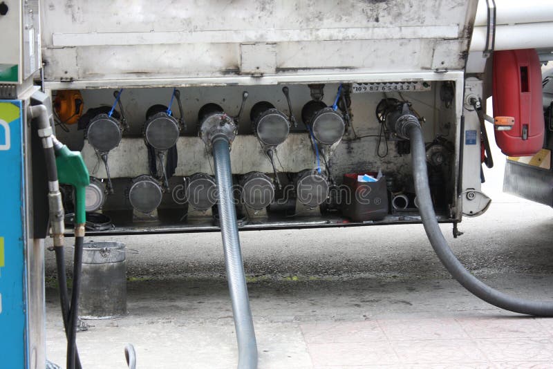 Großer LKW bespritzt für Brennstoffstation, Pumpen und Ölbarrel mit einem Schlauch stockfotos Großer LKW bespritzt für Brennstoffstation, Pumpen und Ölbarrel mit einem Schlauch stockfotos