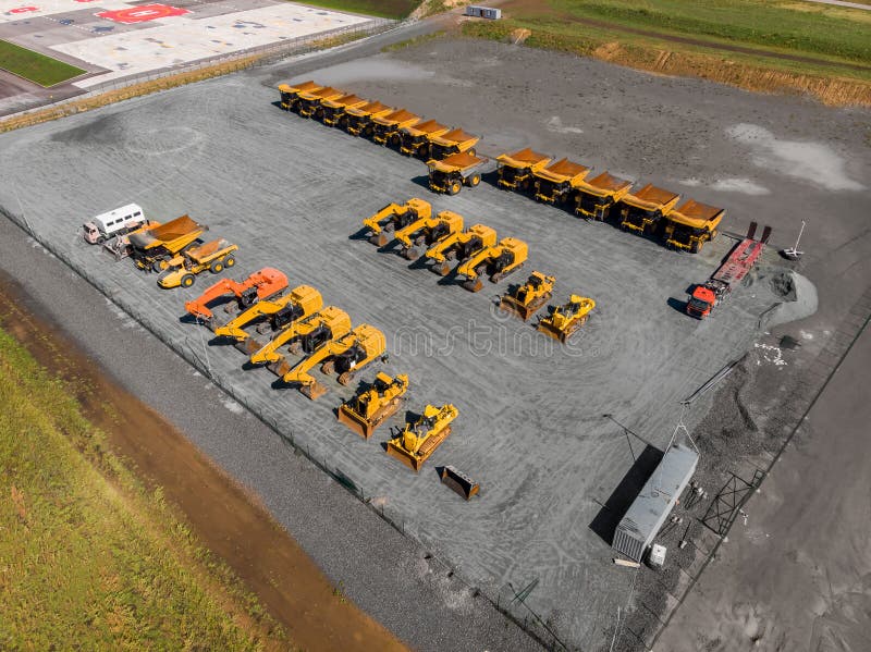 Large parking lot with big yellow mining truck, bulldozers for coal industry, ore and gold. Concept sale of industrial equipment. Aerial top view. Large parking lot with big yellow mining truck, bulldozers for coal industry, ore and gold. Concept sale of industrial equipment. Aerial top view.