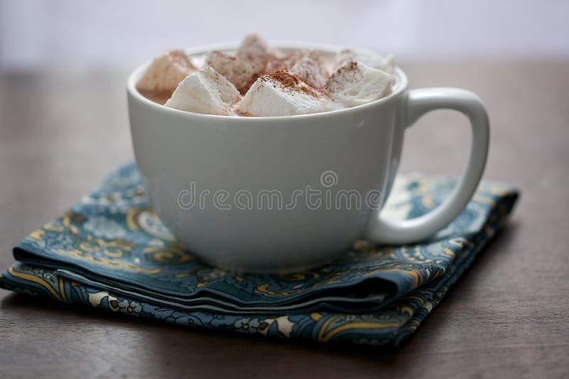 Großer weißer Becher mit Eibischen und heißem Kakao auf Serviette stockfoto