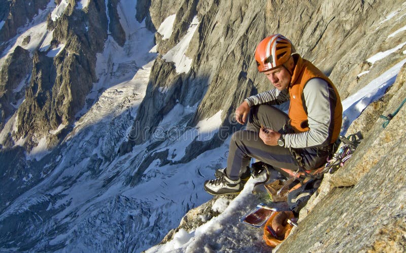 Climber enjoying his dinner, before a bivouac, in the Cassin route of the Grande Jorasses, Alps. Chamonix, Mont Blanc region, France. Climber enjoying his dinner, before a bivouac, in the Cassin route of the Grande Jorasses, Alps. Chamonix, Mont Blanc region, France