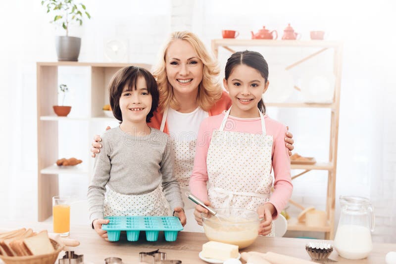 Großmutter mit ihren Enkelkindern kocht Gebäck in der Küche Schokoladenplätzchenmischung, backende Formen und Bonbon schmücken au lizenzfreies stockbild Großmutter mit ihren Enkelkindern kocht Gebäck in der Küche Schokoladenplätzchenmischung, backende Formen und Bonbon schmücken au lizenzfreies stockbild