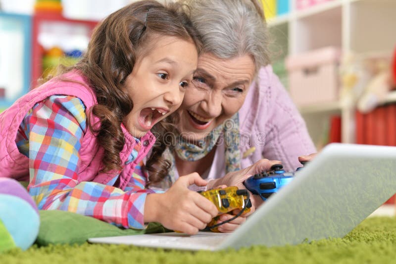 Großmutter mit ihrer Enkelin, die Computerspiel spielt