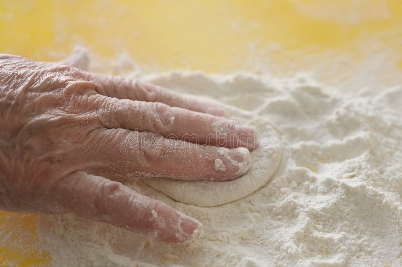 Grandmother`s hand close-up. Elderly woman cooks pies in the kitchen. Grandmother`s hand close-up. Elderly woman cooks pies in the kitchen