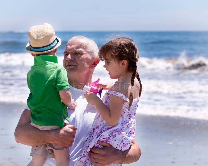 Großvater, der seine Grandkids hält lizenzfreies stockbild Großvater, der seine Grandkids hält lizenzfreies stockbild