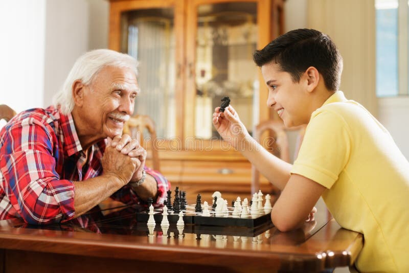 Großvater, der zu Hause Schach-Brettspiel mit Enkel spielt