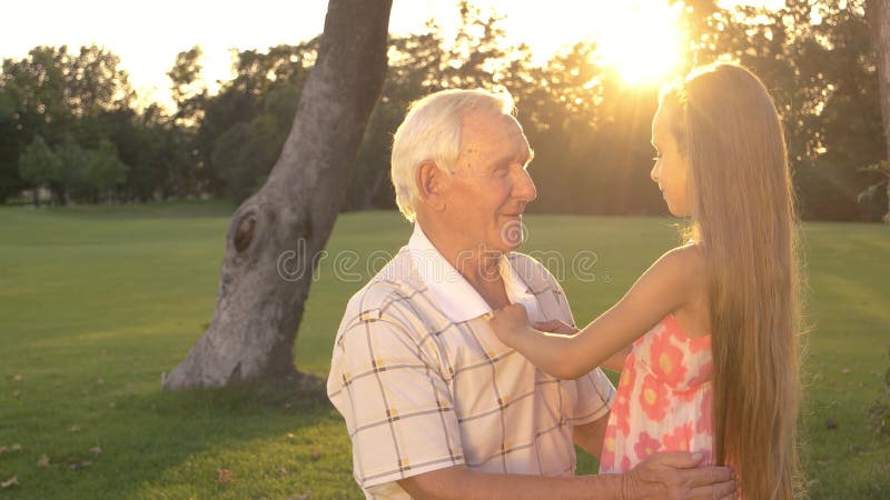 Großvater und kleines Mädchen, die draußen sprechen