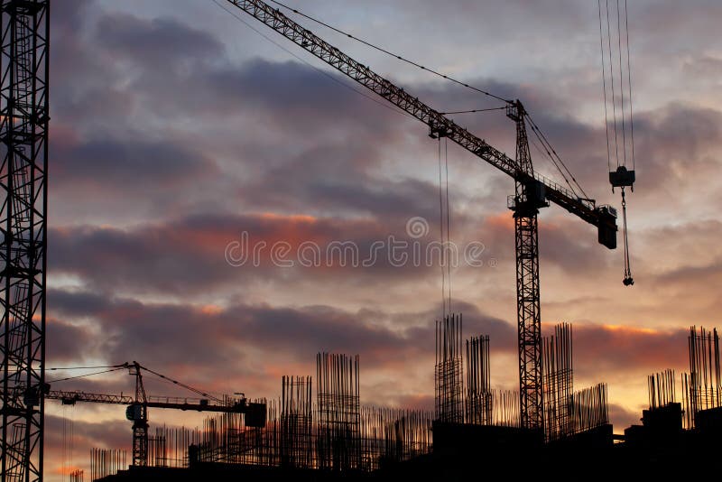 Gru di costruzione e siluette industriali della costruzione sopra il sole ad alba immagini stock Gru di costruzione e siluette industriali della costruzione sopra il sole ad alba immagini stock