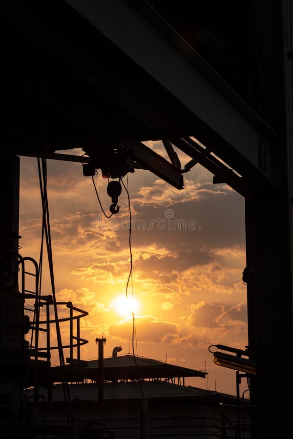 Gru a gancio industriale di Silhouette in fondo al tramonto fotografia stock libera da diritti Gru a gancio industriale di Silhouette in fondo al tramonto fotografia stock libera da diritti