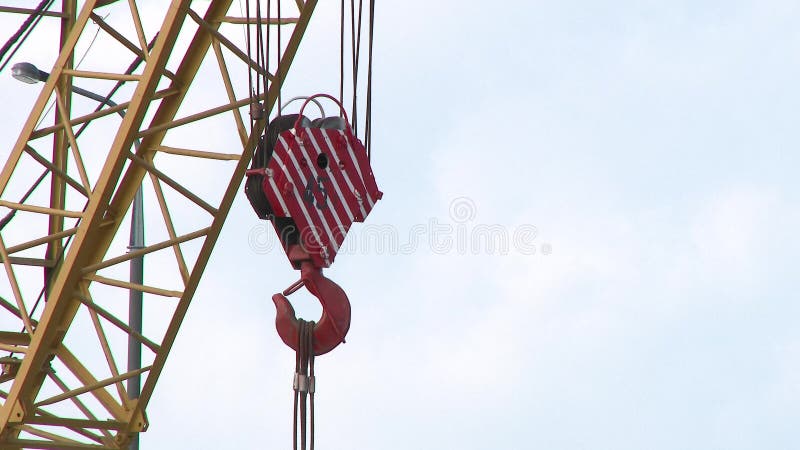 Grua e gancho. ganhe uma grua velha e enferrujada cor amarela feche o gancho de guindaste para a grua na fábrica 4k