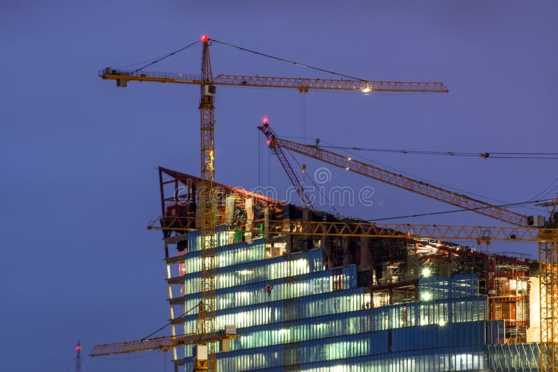 Grue sur le bâtiment en construction la nuit images libres de droits Grue sur le bâtiment en construction la nuit images libres de droits