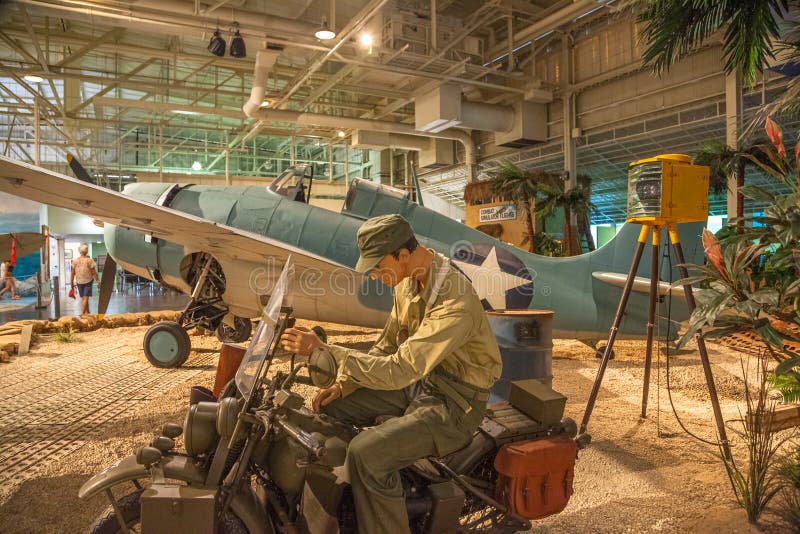 Honolulu, Oahu, Hawaii, United States - August 2016: American Marine on motorcycle Grumman F4F-3 Wildcat Fighter of 1942 of the Pearl Harbor Aviation Museum of Hawaii. American aircraft in World War 2. Honolulu, Oahu, Hawaii, United States - August 2016: American Marine on motorcycle Grumman F4F-3 Wildcat Fighter of 1942 of the Pearl Harbor Aviation Museum of Hawaii. American aircraft in World War 2