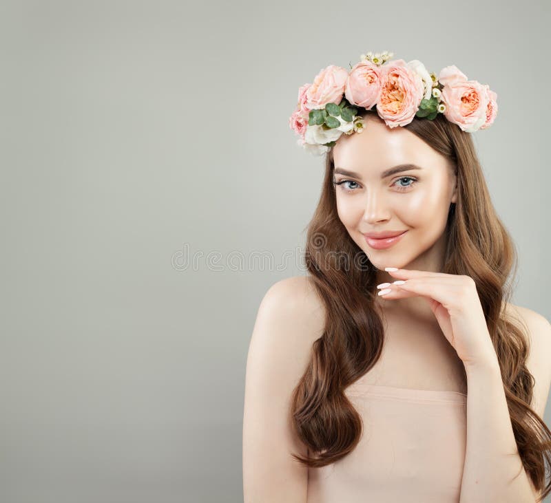grund kvinna f?r gladlynt djupf?ltst?ende Ung modell med klar hud, långt sunt lockigt hår och blommor Skincare och ansikts- behan arkivbild grund kvinna f?r gladlynt djupf?ltst?ende Ung modell med klar hud, långt sunt lockigt hår och blommor Skincare och ansikts- behan arkivbild