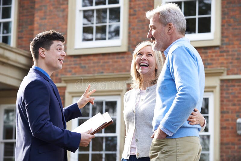 Grundstücksmakler, der reife Paare um Haus zu verkaufen zeigt stockbild Grundstücksmakler, der reife Paare um Haus zu verkaufen zeigt stockbild