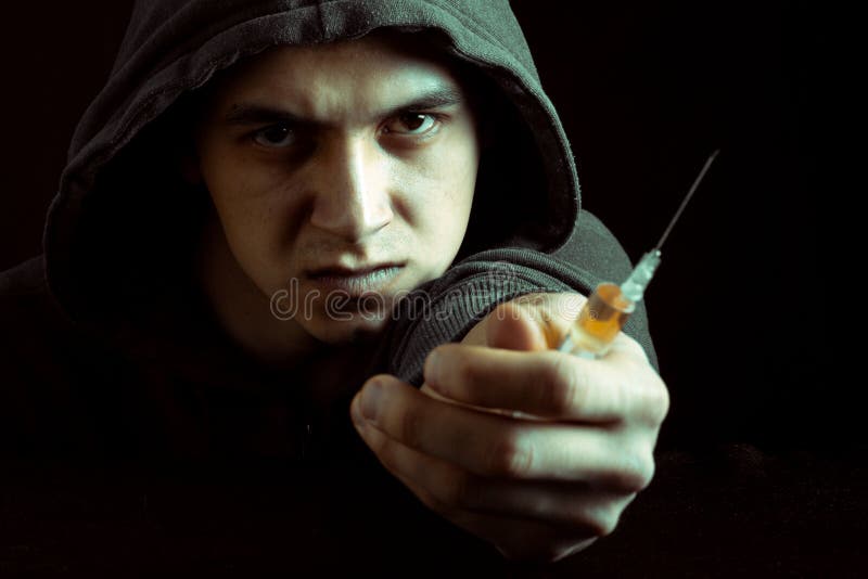 Grungebeeld van een gedeprimeerde drugverslaafde die een spuit en drugs bekijken royalty-vrije stock fotografie Grungebeeld van een gedeprimeerde drugverslaafde die een spuit en drugs bekijken royalty-vrije stock fotografie