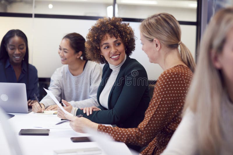 Grupa biznesmenek współpracujących w twórczym spotkaniu przy stole w nowoczesnym biurze