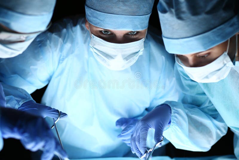 Grupa chirurdzy przy pracy działaniem w chirurgicznie theatre